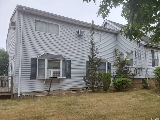 view of side of home featuring a wall mounted AC, a yard, and cooling unit