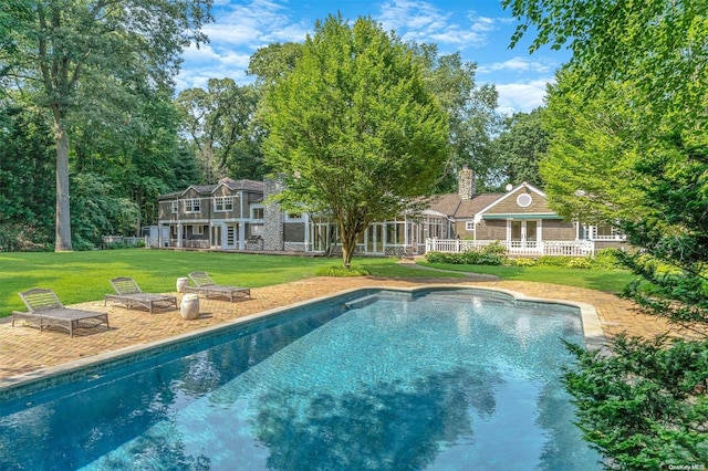 view of pool with a patio area and a lawn