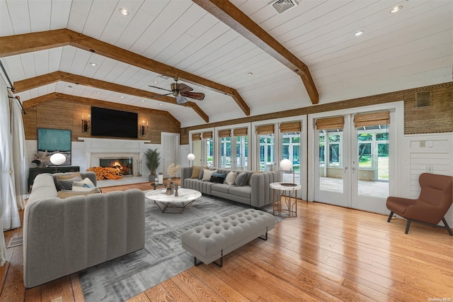 living room featuring lofted ceiling with beams, ceiling fan, light wood-type flooring, and a wealth of natural light