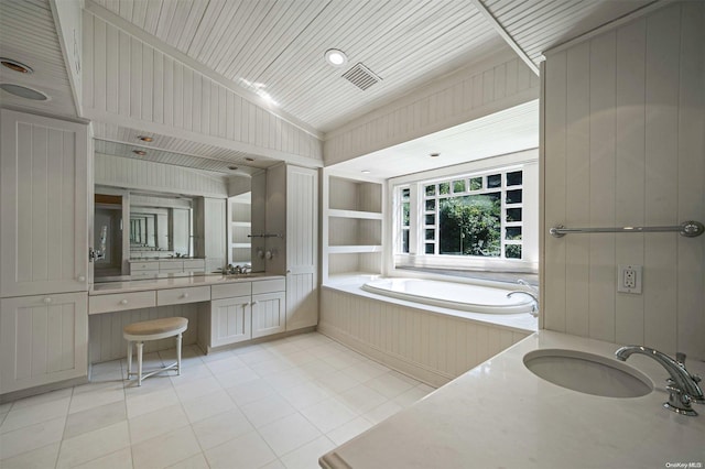 bathroom with tile patterned flooring, vanity, a tub to relax in, and vaulted ceiling