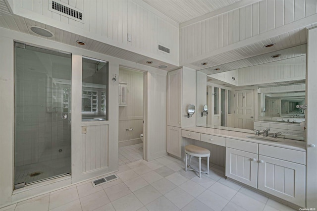 bathroom featuring tile patterned flooring, vanity, a shower with shower door, and toilet