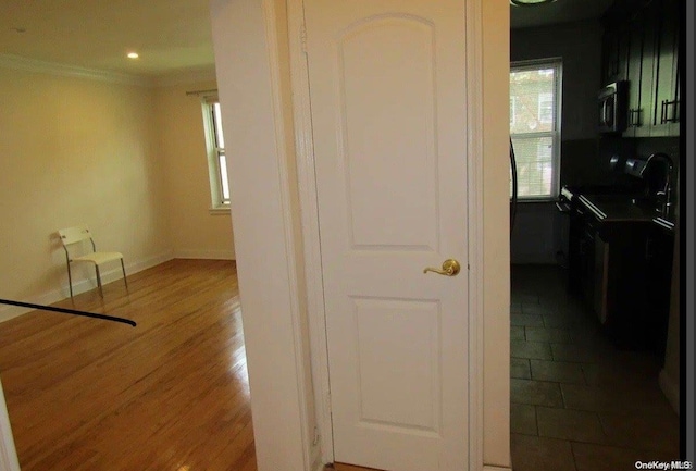 hall featuring wood-type flooring and ornamental molding