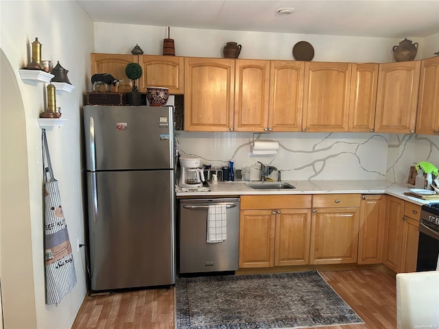 kitchen with tasteful backsplash, sink, appliances with stainless steel finishes, and dark wood-type flooring