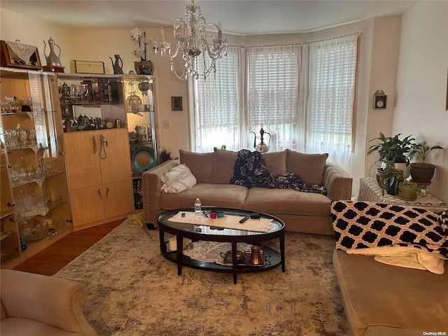 living room featuring wood-type flooring and an inviting chandelier