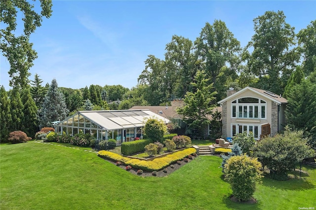 exterior space featuring a lawn and glass enclosure