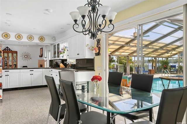 dining space featuring sink and an inviting chandelier