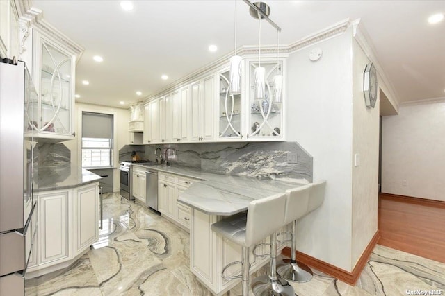 kitchen with pendant lighting, decorative backsplash, a kitchen breakfast bar, and white cabinetry