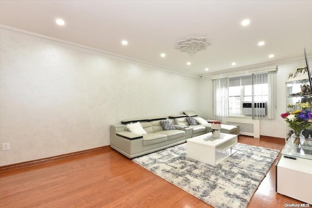 living room with hardwood / wood-style flooring, ornamental molding, and radiator