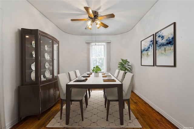 dining space with ceiling fan and dark hardwood / wood-style flooring