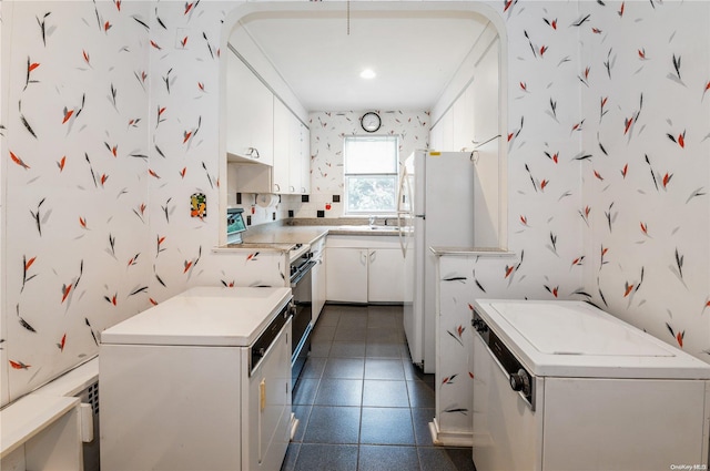 kitchen featuring white cabinets, white appliances, dark tile patterned floors, and sink