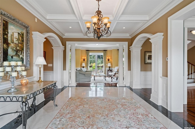 entrance foyer with ornate columns, coffered ceiling, beamed ceiling, crown molding, and a chandelier