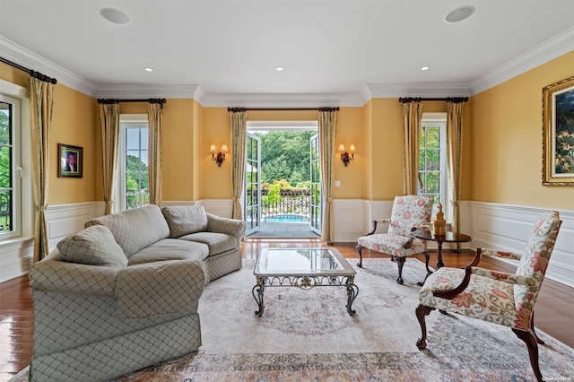 living room with a wealth of natural light, hardwood / wood-style floors, and crown molding