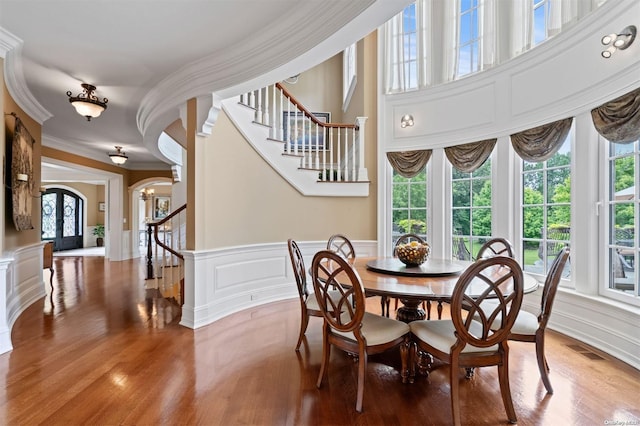 dining room with hardwood / wood-style floors, french doors, and ornamental molding