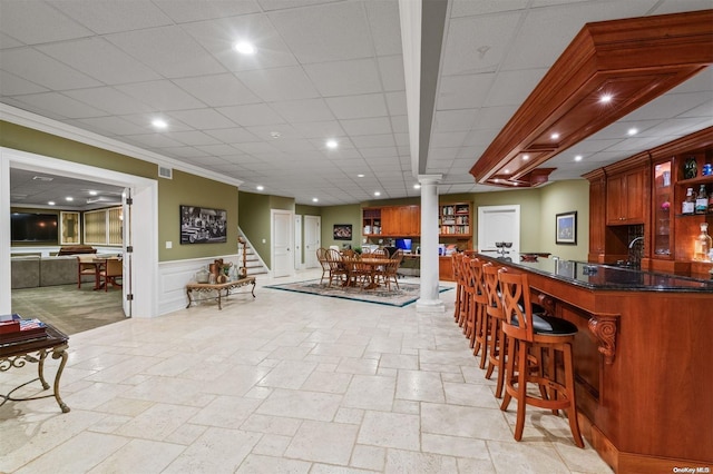 bar with ornate columns and crown molding