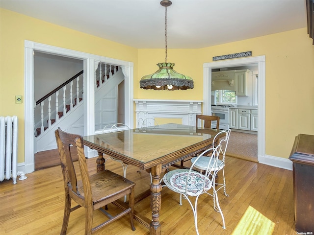 dining area featuring radiator and light hardwood / wood-style flooring