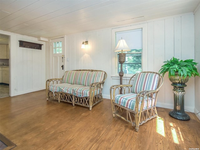 sitting room featuring wooden walls and hardwood / wood-style floors