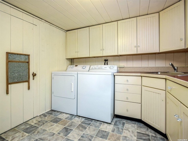 washroom with washer and clothes dryer, cabinets, sink, wooden walls, and wood ceiling