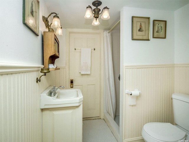 bathroom with walk in shower, tile patterned flooring, vanity, and toilet