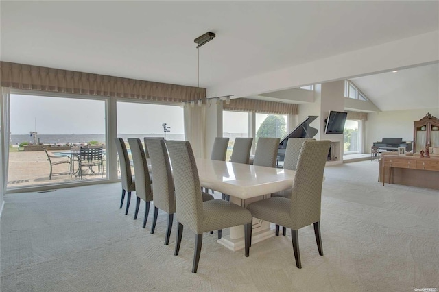 carpeted dining space with a water view and lofted ceiling