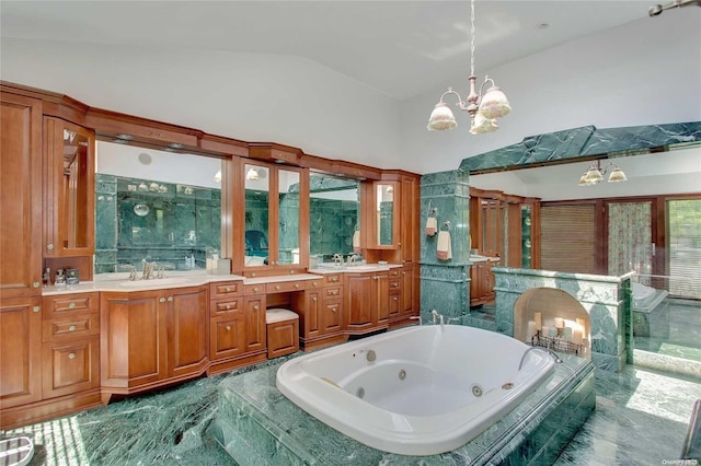 bathroom with vanity, a relaxing tiled tub, lofted ceiling, and an inviting chandelier