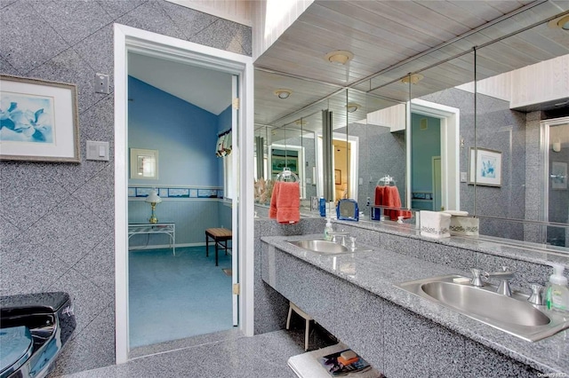 bathroom featuring tile walls and sink