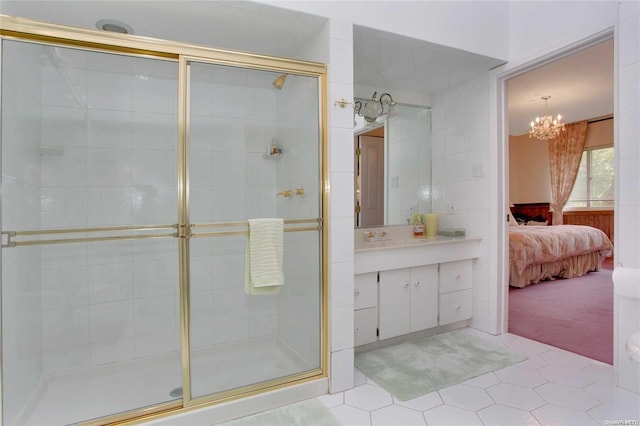 bathroom featuring tile patterned flooring, vanity, a shower with shower door, and a notable chandelier