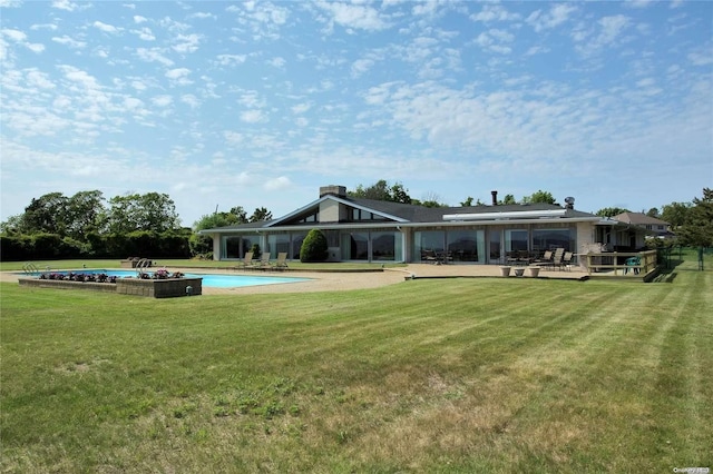 rear view of property with a lawn and a patio