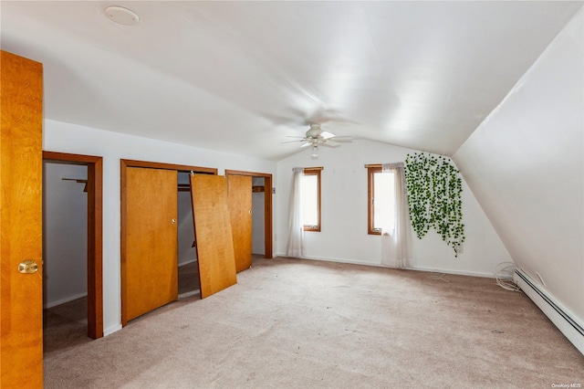 additional living space with carpet flooring, baseboard heating, lofted ceiling, and ceiling fan