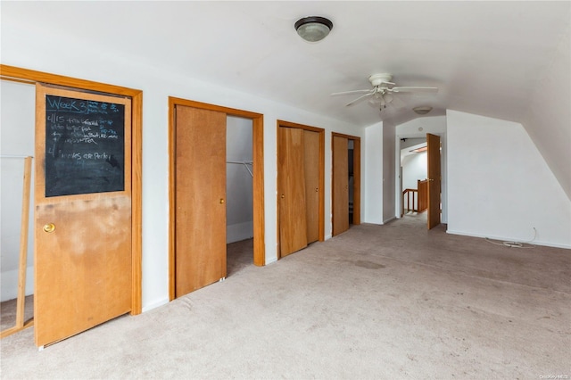 additional living space with light colored carpet, ceiling fan, and lofted ceiling