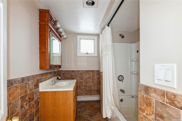 bathroom with baseboard heating, shower / tub combo with curtain, vanity, and tile walls