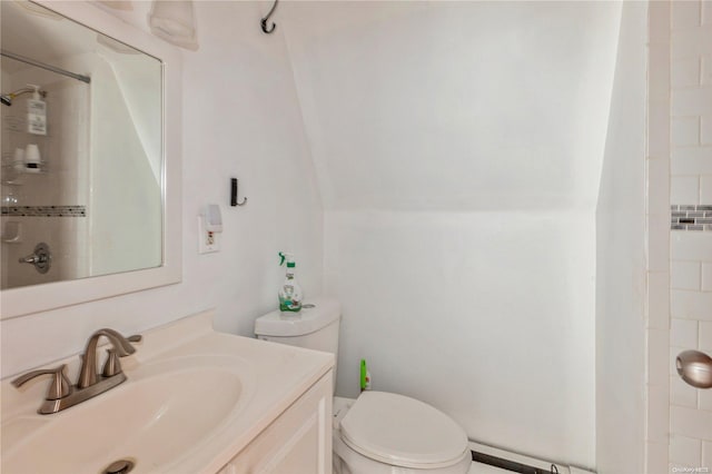 bathroom with a tile shower, vanity, and toilet