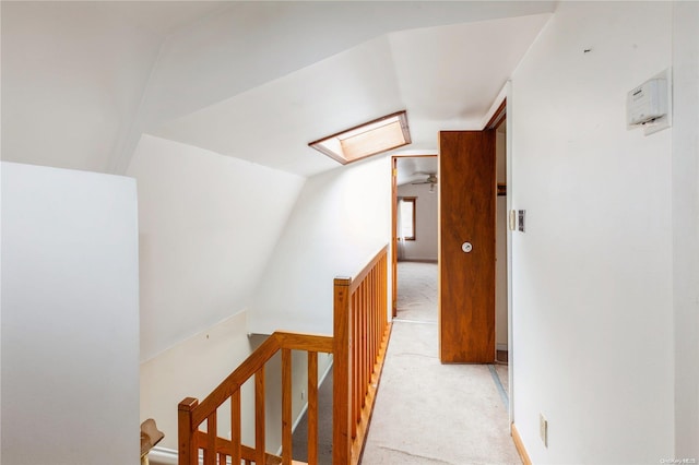 hallway featuring light colored carpet and vaulted ceiling