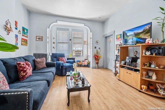 living room with hardwood / wood-style floors, radiator, and cooling unit