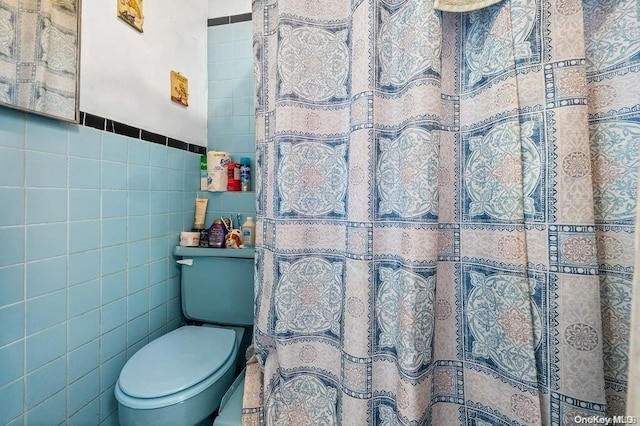 bathroom with tile walls and toilet