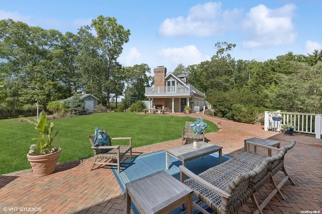 view of patio with a balcony and a storage shed