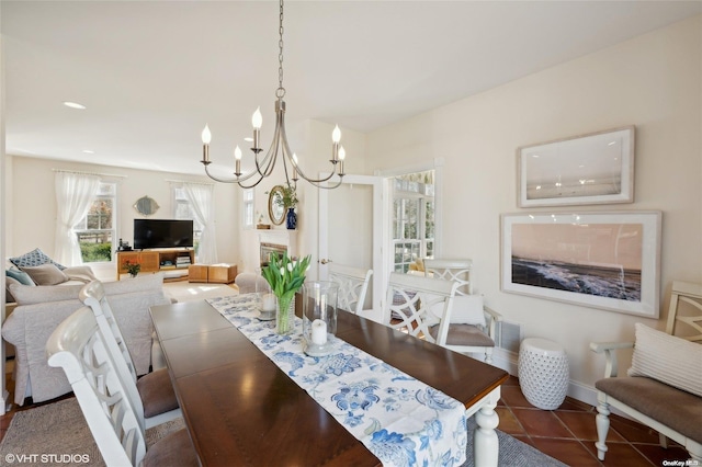 dining room with dark tile patterned floors and a chandelier