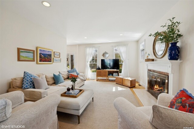 living room featuring light colored carpet and a brick fireplace