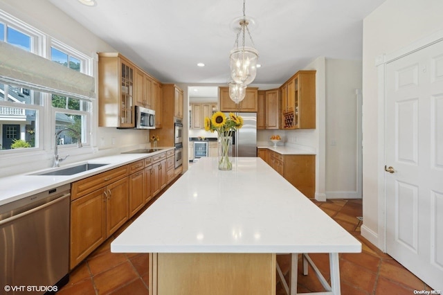 kitchen featuring a center island, stainless steel appliances, hanging light fixtures, and sink