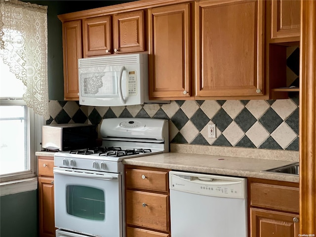 kitchen featuring tasteful backsplash, sink, and white appliances