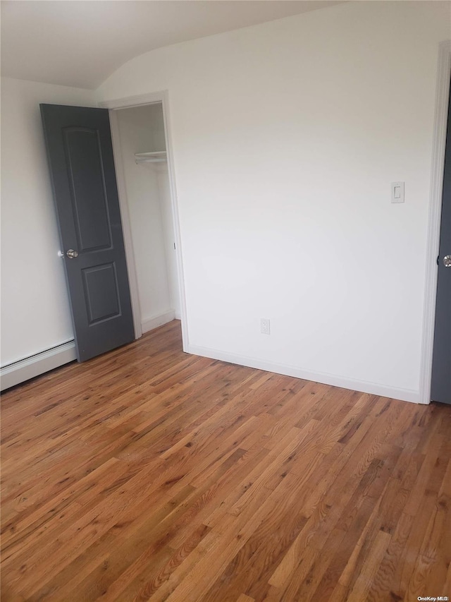 unfurnished room featuring a baseboard radiator and hardwood / wood-style flooring