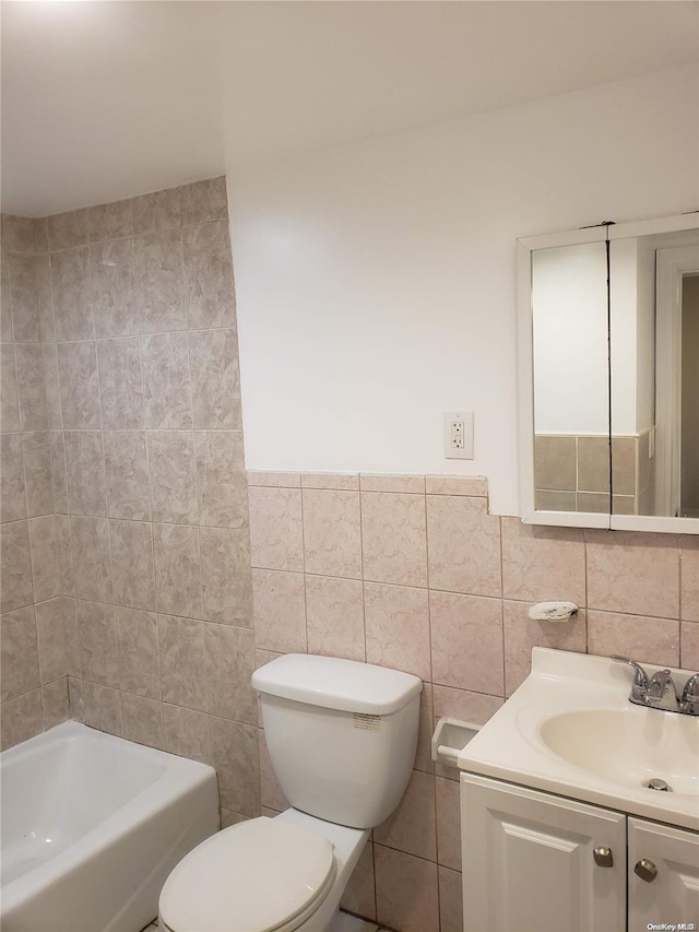 bathroom featuring vanity, toilet, and tile walls