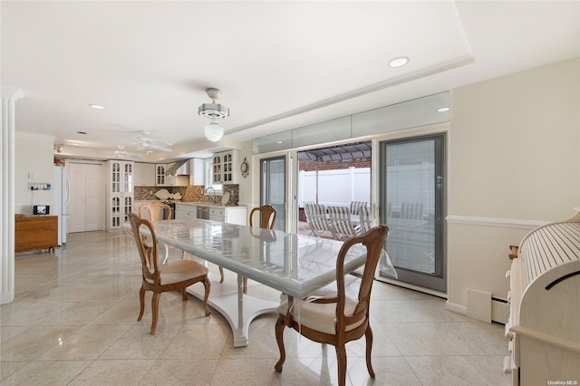 dining room featuring ceiling fan, a baseboard heating unit, and sink