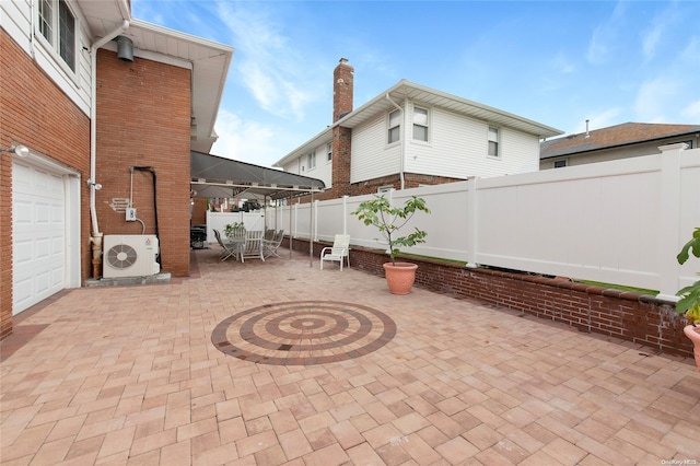 view of patio with ac unit and a garage