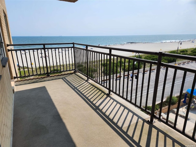 balcony featuring a water view and a view of the beach