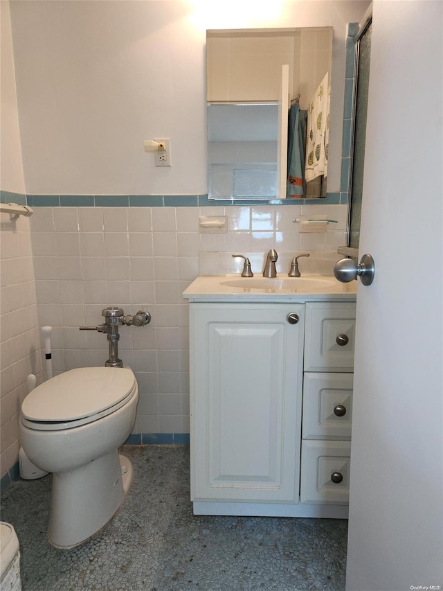 bathroom featuring vanity, toilet, and tile walls