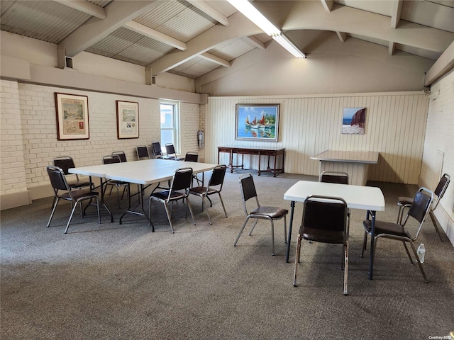 dining space with vaulted ceiling with beams, dark carpet, and brick wall