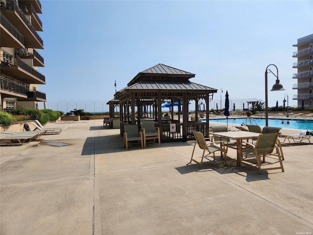 exterior space featuring a gazebo, a water view, and a community pool