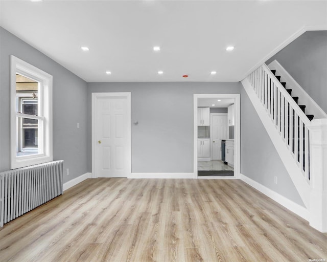 interior space with radiator heating unit and light hardwood / wood-style flooring