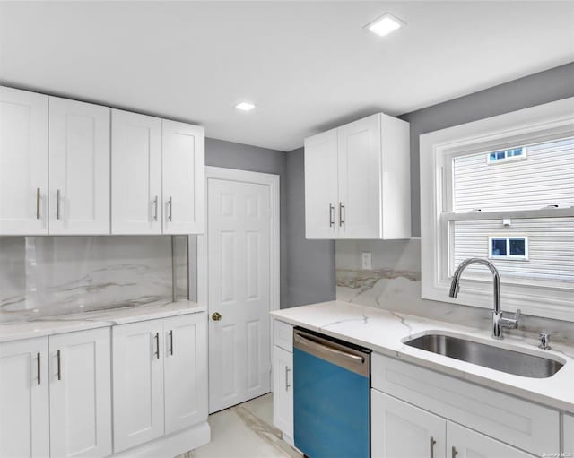 kitchen with backsplash, white cabinetry, stainless steel dishwasher, and sink