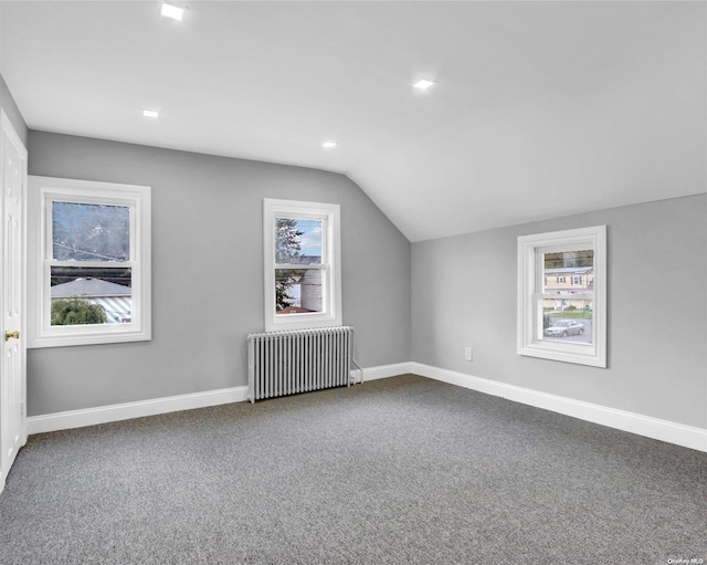 additional living space with carpet, radiator, and vaulted ceiling